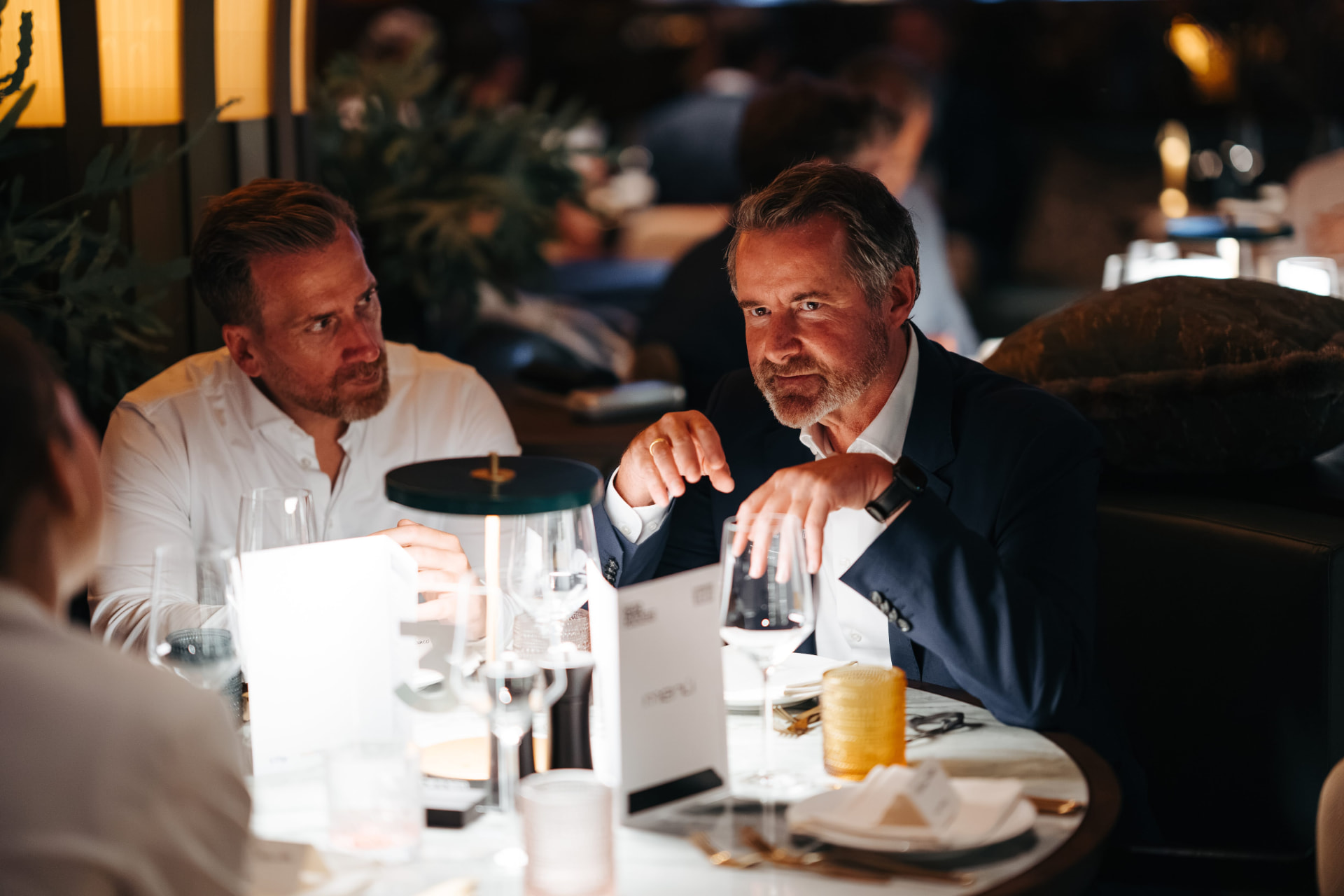 Zwei Gäste im Gespräch beim Dinner